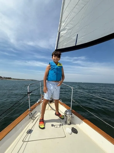 Guest standing at the bow rail while sailing off Oak Bluffs