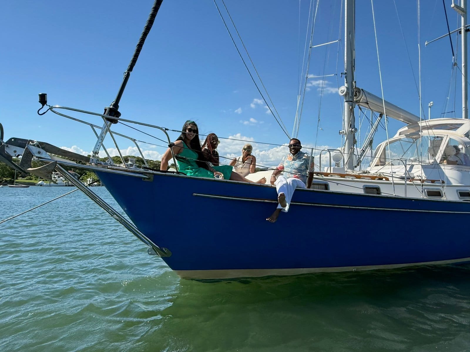 Guests relaxing on the bow of Our Passion at anchor during a full day private sailing charter