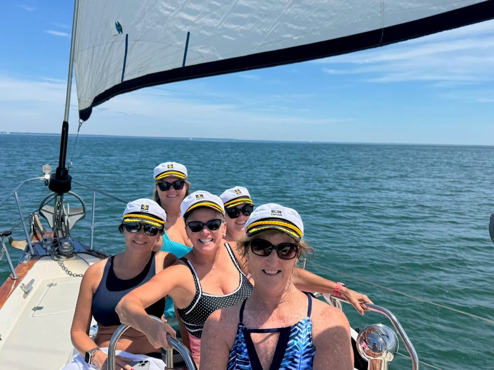 Guests at the helm of Our Passion under sail on a half day private charter