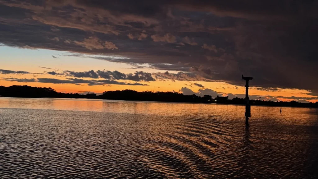 Sailing charter weather on Martha's Vineyard: storm clouds clearing to a golden sunset over calm water